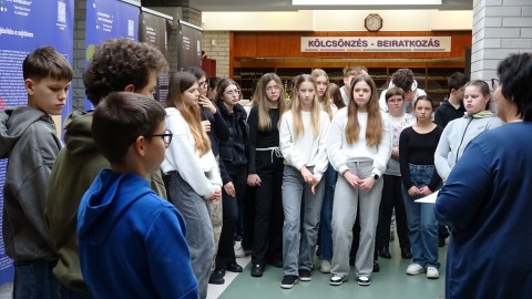 Középiskolai diákok meghallgatják a tárlatvezetést.